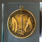President's Award medallion depicting a quill, flame and sword.