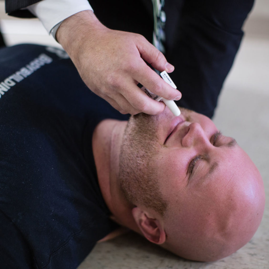 Chris Jones demonstrates the Naloxene nasal spray on a LEIC volunteer