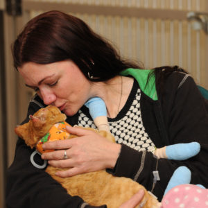 A woman cuddles her bandaged cat, a burn victim from the Gatlinburg fire in the UT College of Veterinary Medicine
