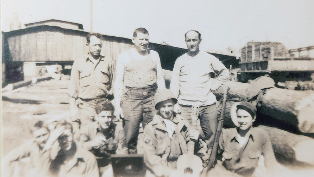 T Joe Walker, holding guitar, with other soldiers during World War II.