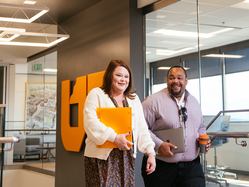 UTSA staff members walking through the UT Tower office building.
