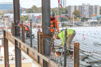 Construction workers welding part of a building.