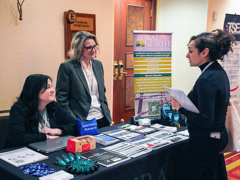 Rural Health representatives talking to a Grand Challenges Summit Attendee.