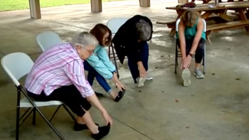 Older women participating in a chair exercise outdoors during the Stay Strong Stay Healthy class offered UT Extension.