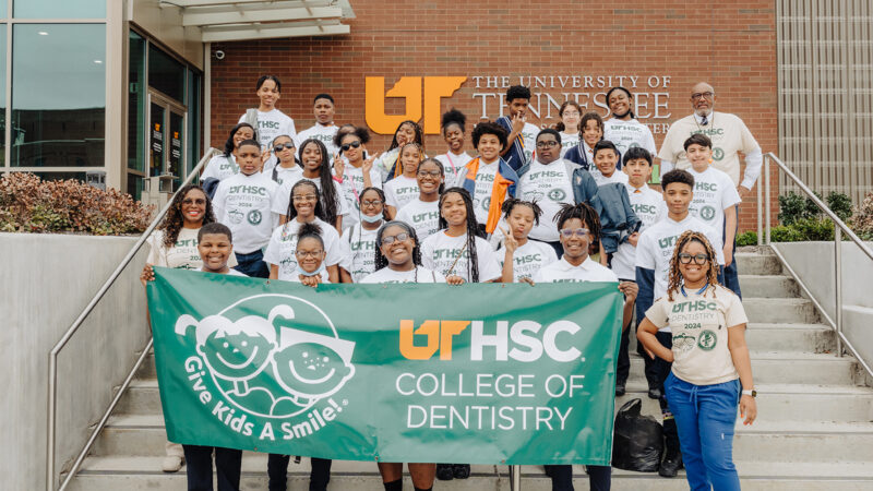 Middle and high school students standing on steps smiling during The UT Health Science Center College of Dentistry's annual Give Kids a Smile Day .
