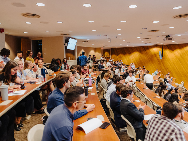 A crowded lecture hall, with elevated tiers of seating.