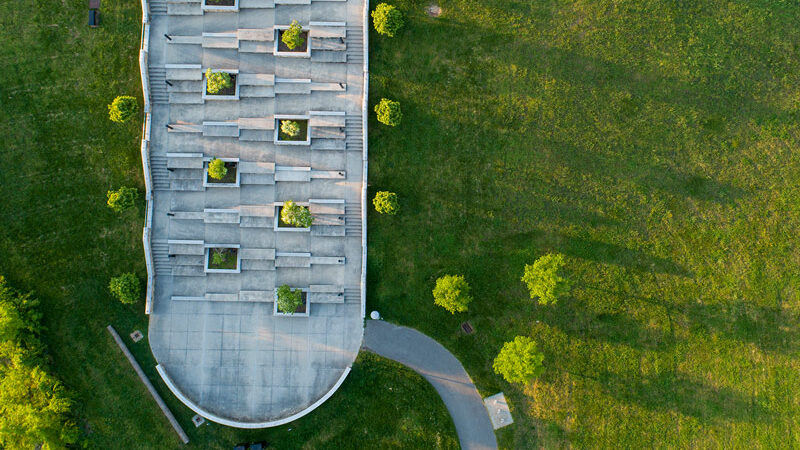 Aerial photo of a green lawn with a zig-zagging concrete walkway cutting down a hill.