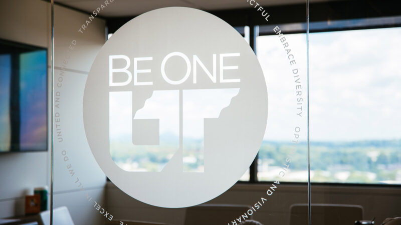 A large glass window with the words "Be One UT" applied as frosted vinyl.