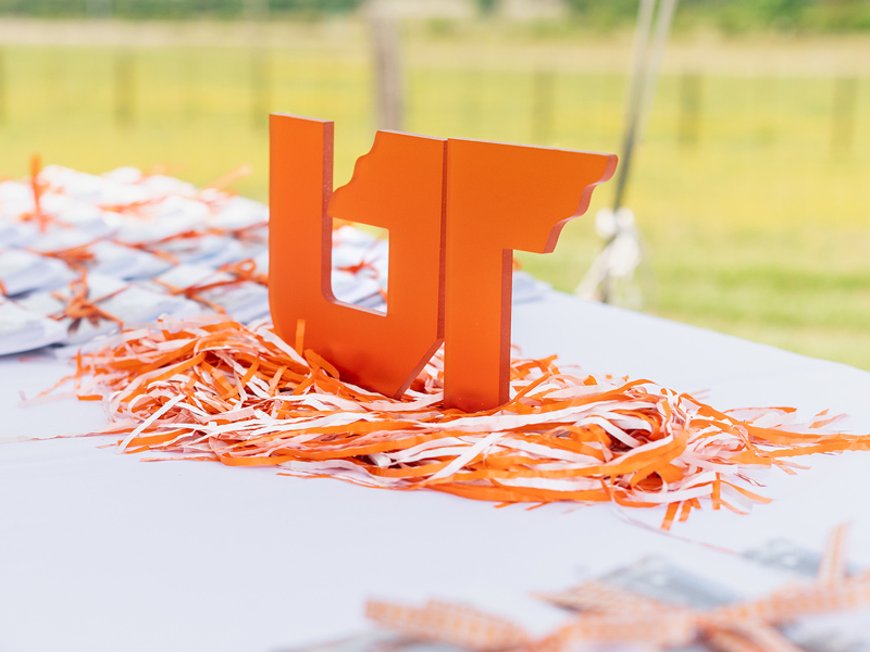 A large, UT icon table-top accessory sitting on a white table, surrounded by other marketing gifts and giveaways.