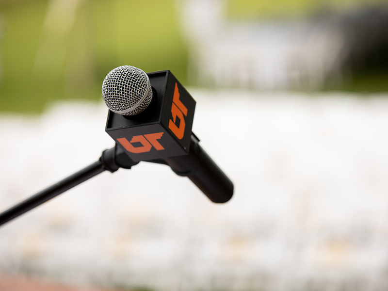 A close-up of a podium microphone with the UT icon.