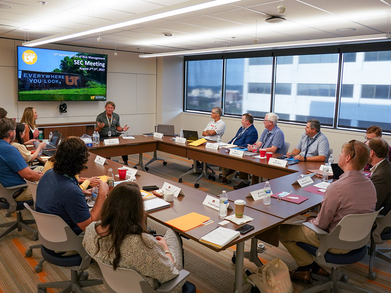 A group of people having a discussion while sitting around a conference table.