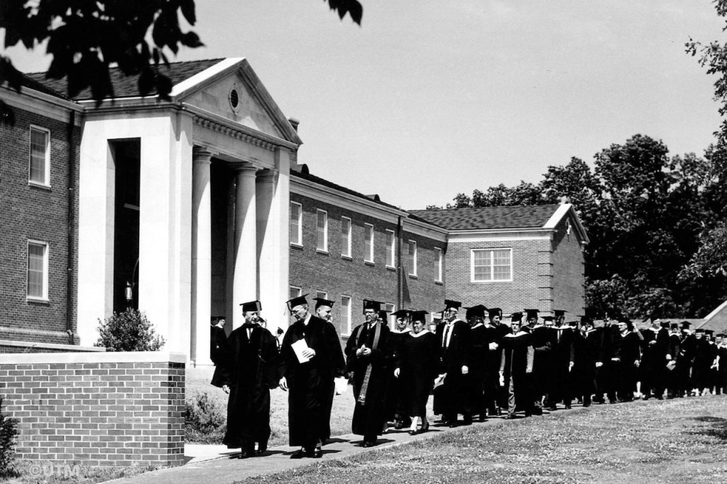 Black and white photo of a group of people wearing commencement regalia.