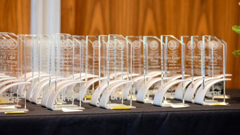 A collection of glass and metal awards sitting on a table, ready for passing out to the winners.