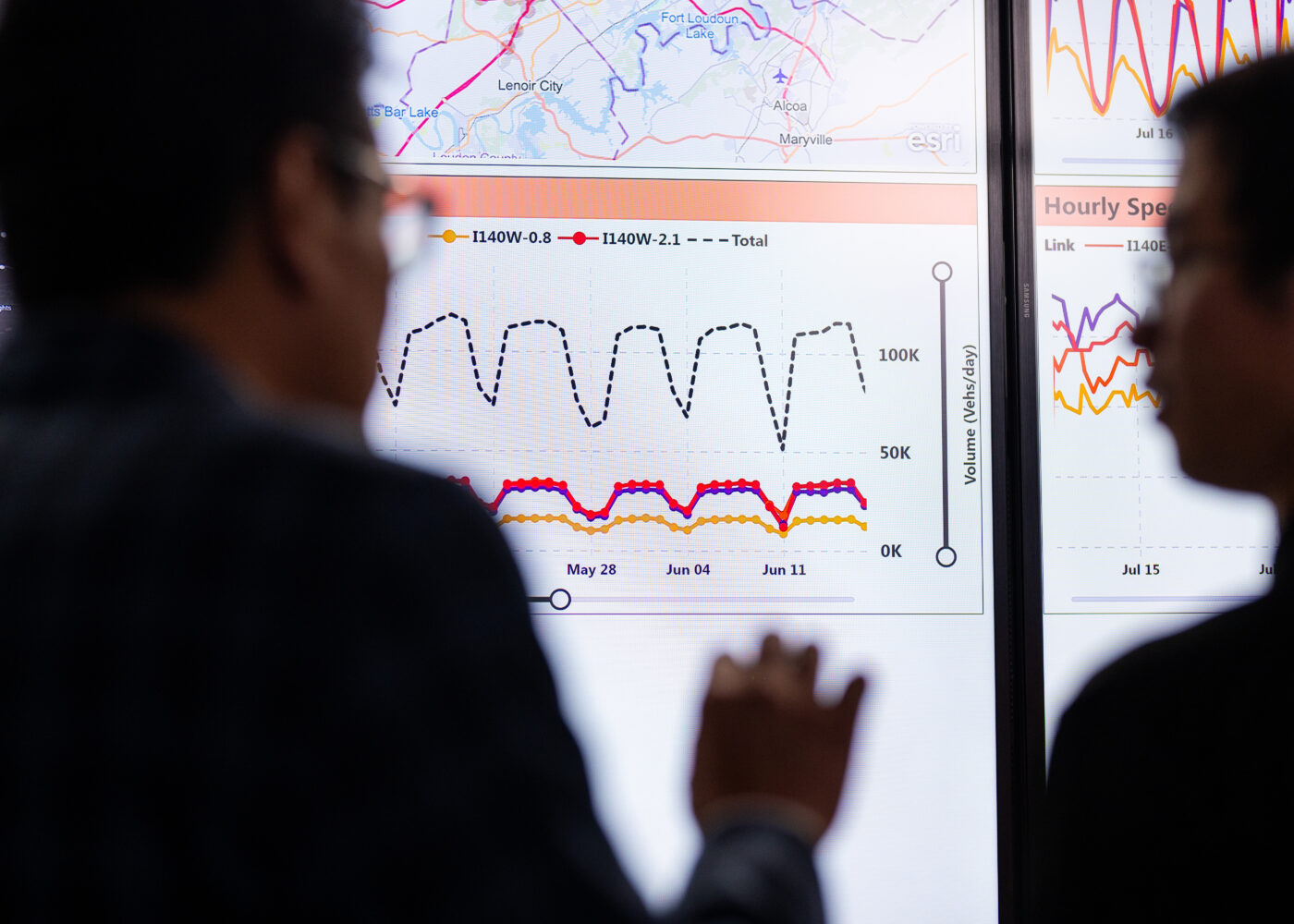 Two people discussing a set of data dashboards.