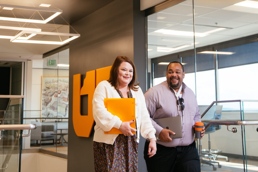 Two UT employees walking up staircase in UT Tower office building.
