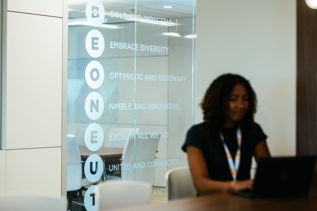 A large glass window with frosted vinyl signage that says "Be One UT".