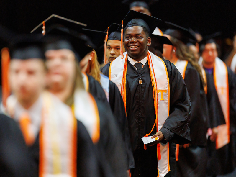 A student smiles while entering the Fall Undergraduate Commencement ceremony inside Thompson-Boling Arena at Food City Center on December 13, 2024. Photo by Steven Bridges/University of Tennessee.