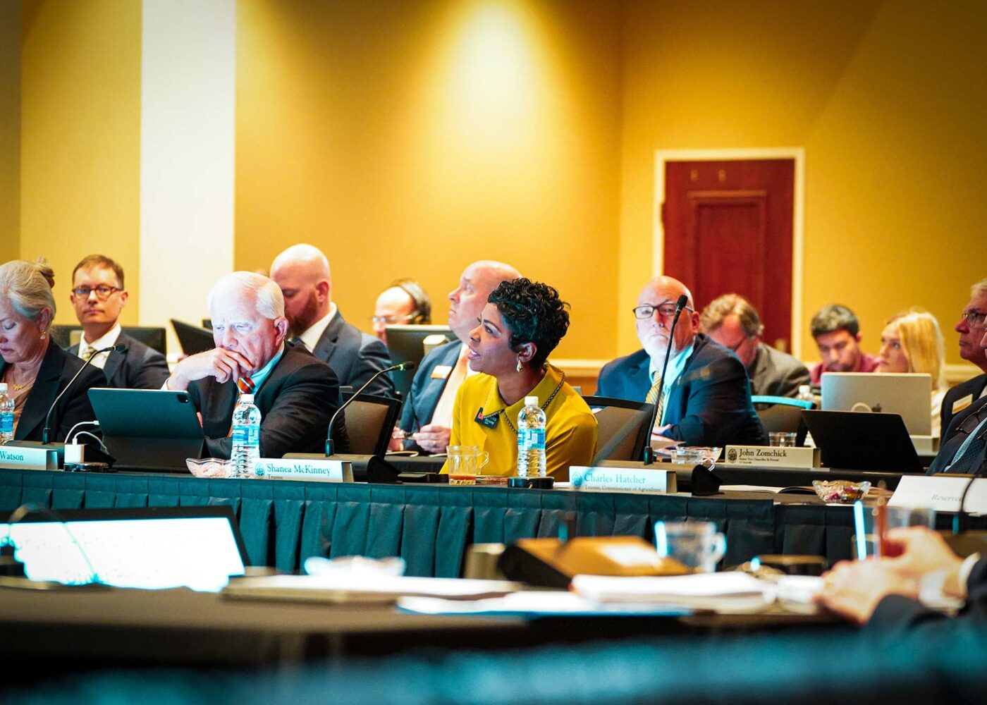 A room full of business people paying attention to a presentation during a board meeting.