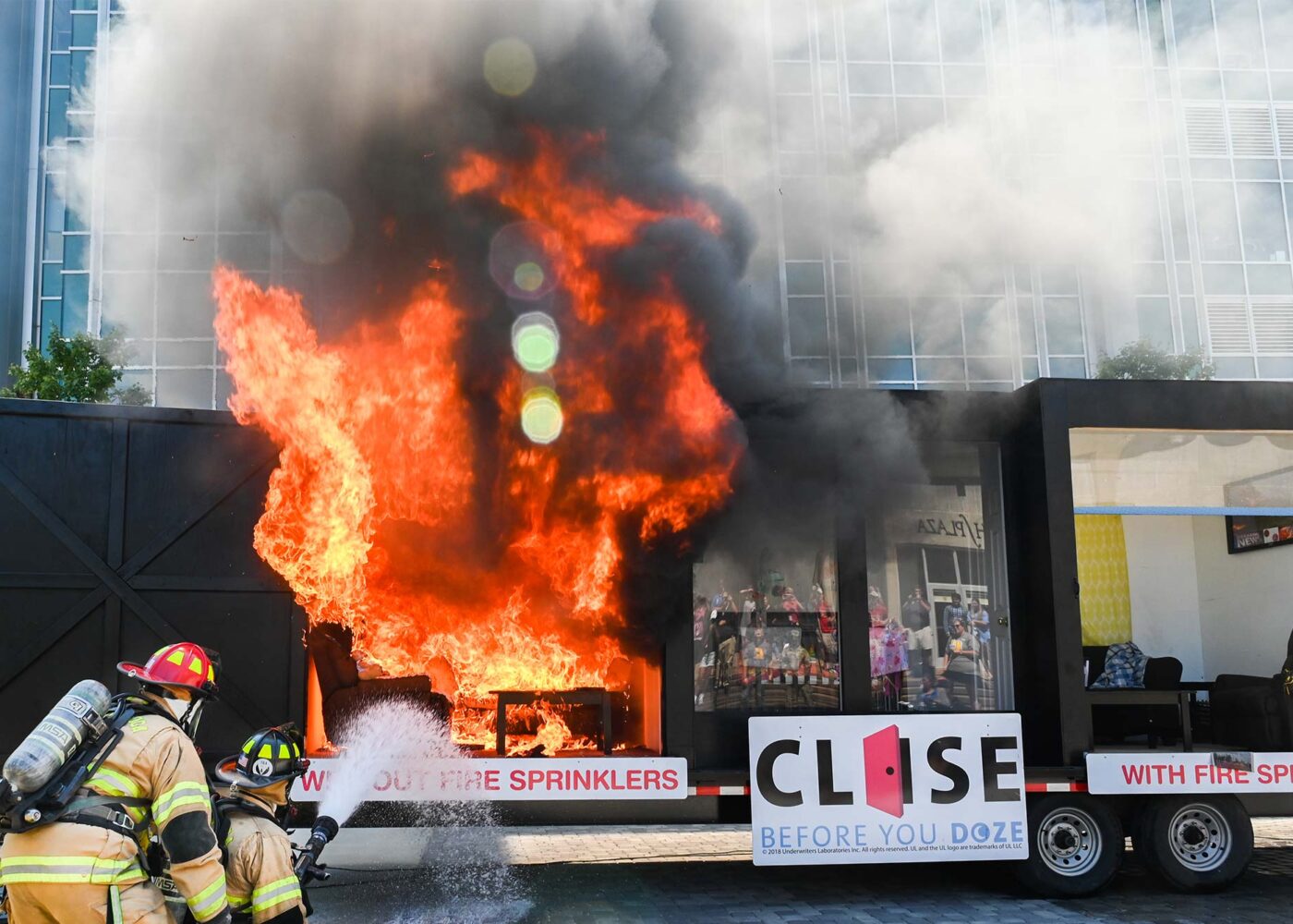 During a safety demonstration, two firefighters demonstrate putting out a fire using a hose only.