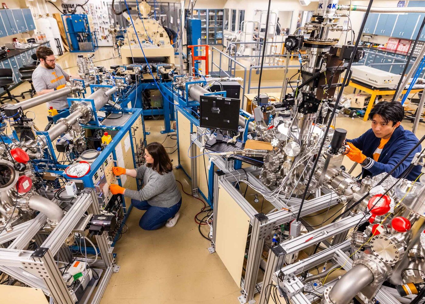 A group of students working on a complicated network of equipment.