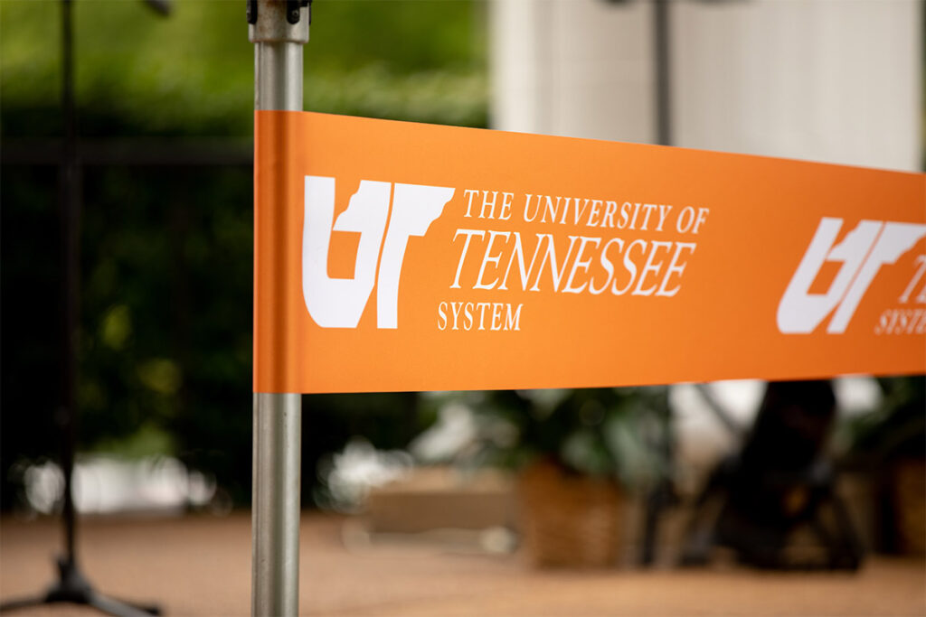 Orange pole banner with the UT System logo.