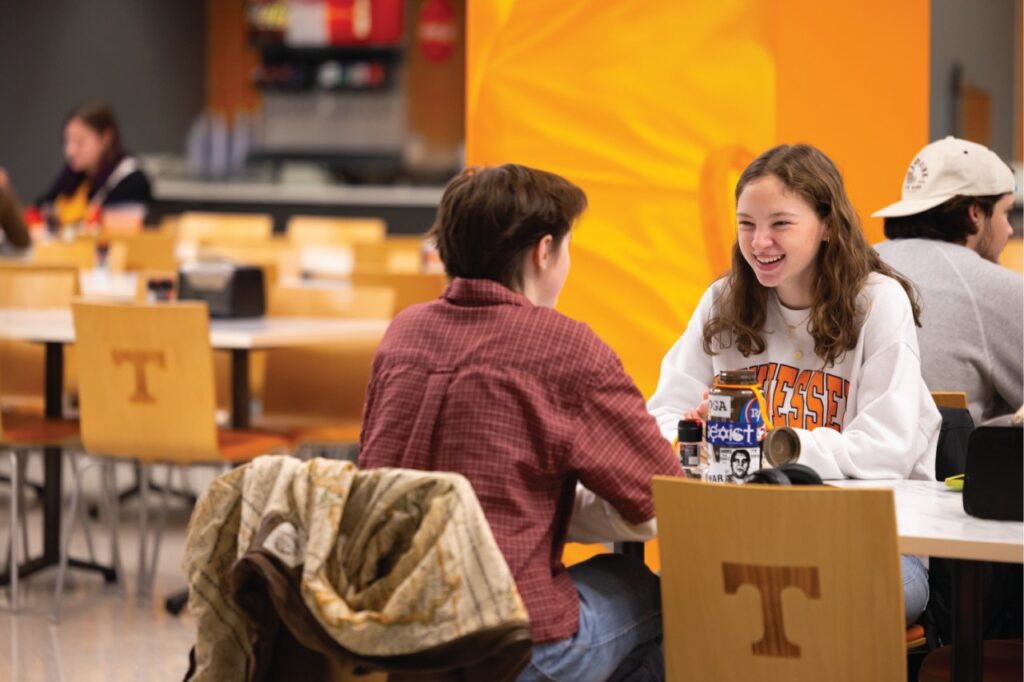 Male and female UTK students siting in a dining area on campus.