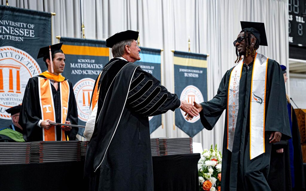 UT President Randy Boyd shaking hands with a graduating student during commencement at UT Southern, May 2025.
