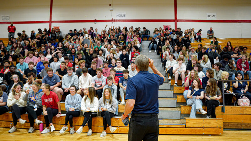 Randy Boyd tossing t-shirts to Brighton high school students inside of a gym during the Find Your UT Tour.