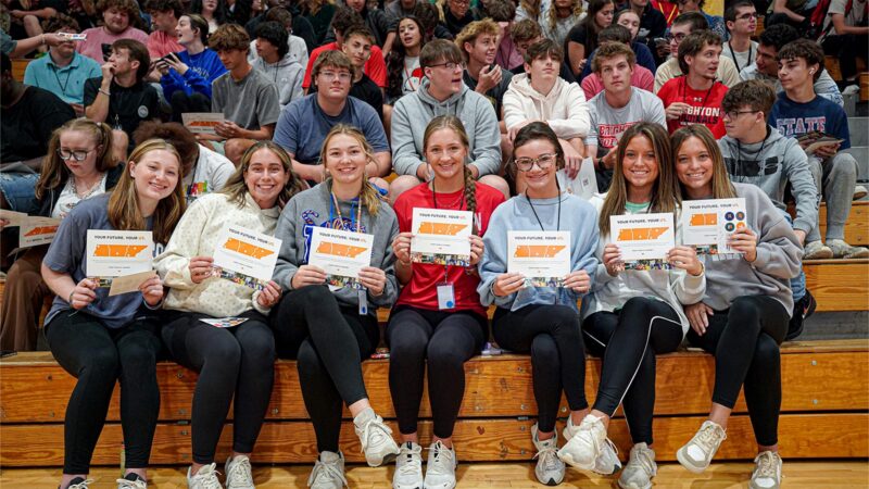 Highschool students holding UT Promise cards.